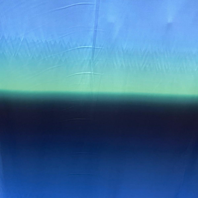 A blue fabric with a horizontal gradient transitioning from light sky blue at the top to a darker navy blue at the bottom, with a soft mint-green band across the middle.