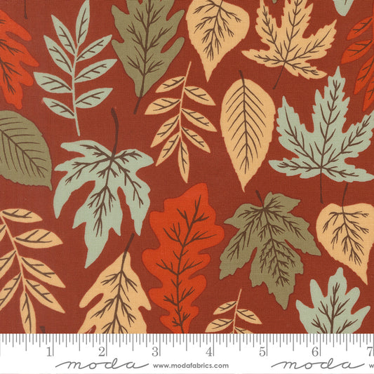 Fabric with autumn leaf pattern on a red background, featuring ruler.
