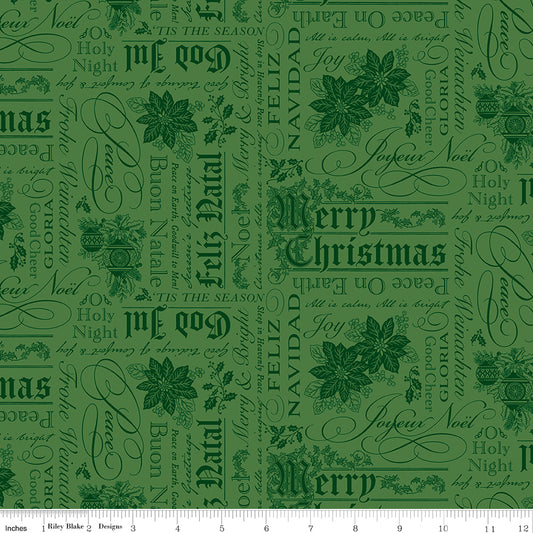 Green fabric with Christmas text and poinsettia patterns on a white ruler background