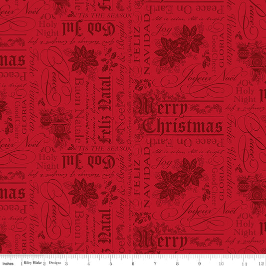 Red fabric with Christmas-themed text and poinsettia patterns on a white ruler background