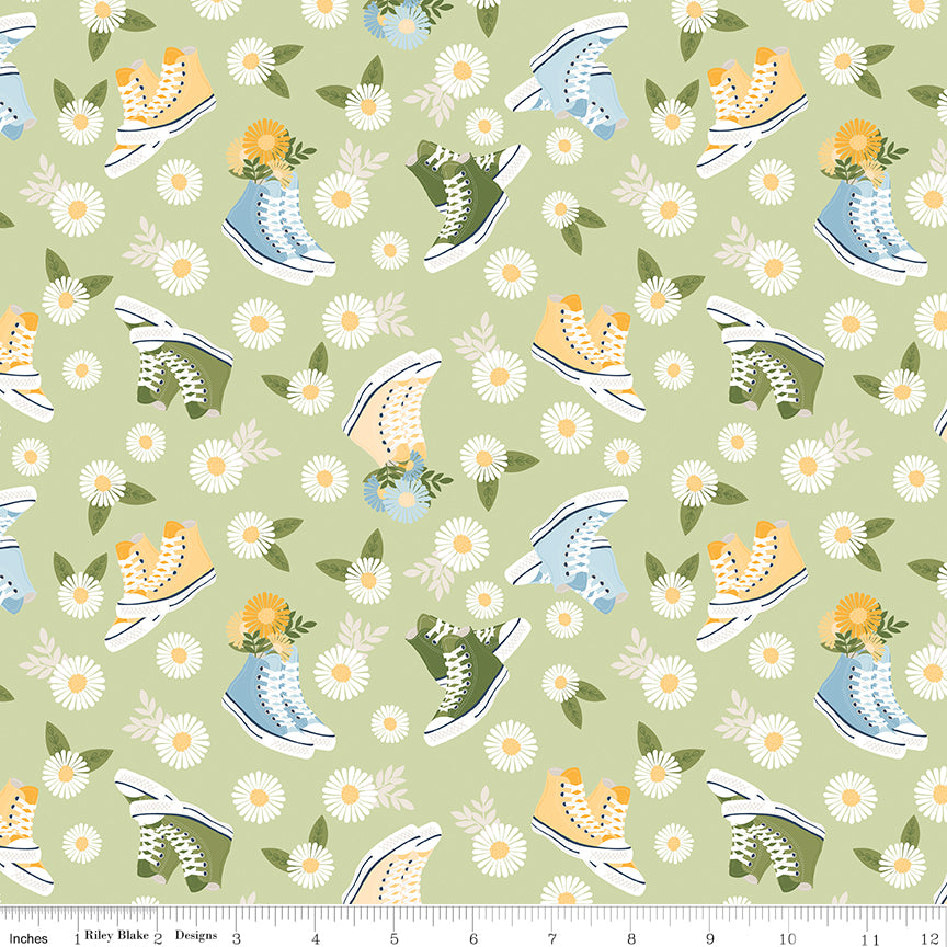 Pattern of sneakers and flowers on a green background with a ruler for scale.