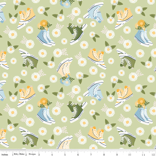 Pattern of sneakers and flowers on a green background with a ruler for scale.