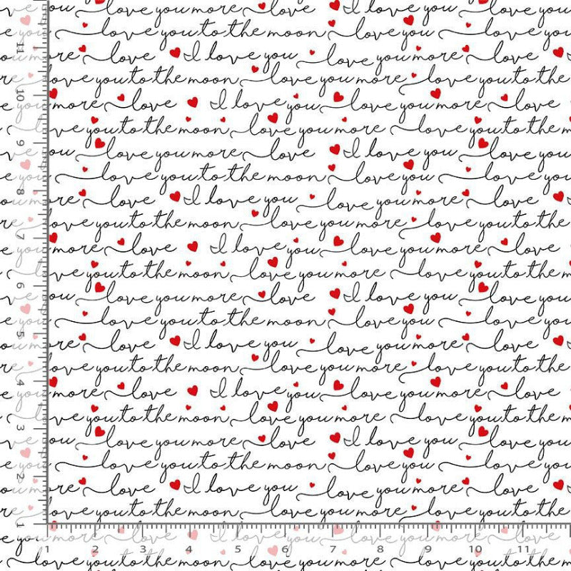 White fabric with a repeating pattern of black cursive text. Interspersed with small red hearts, shown with a ruler on the left to indicate scale.