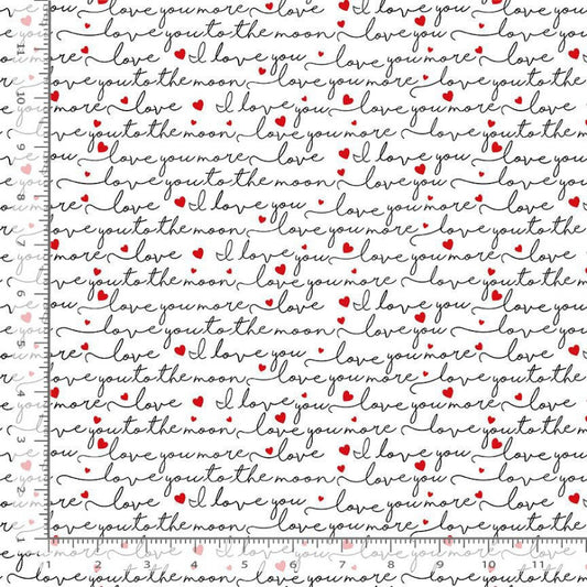 White fabric with a repeating pattern of black cursive text. Interspersed with small red hearts, shown with a ruler on the left to indicate scale.