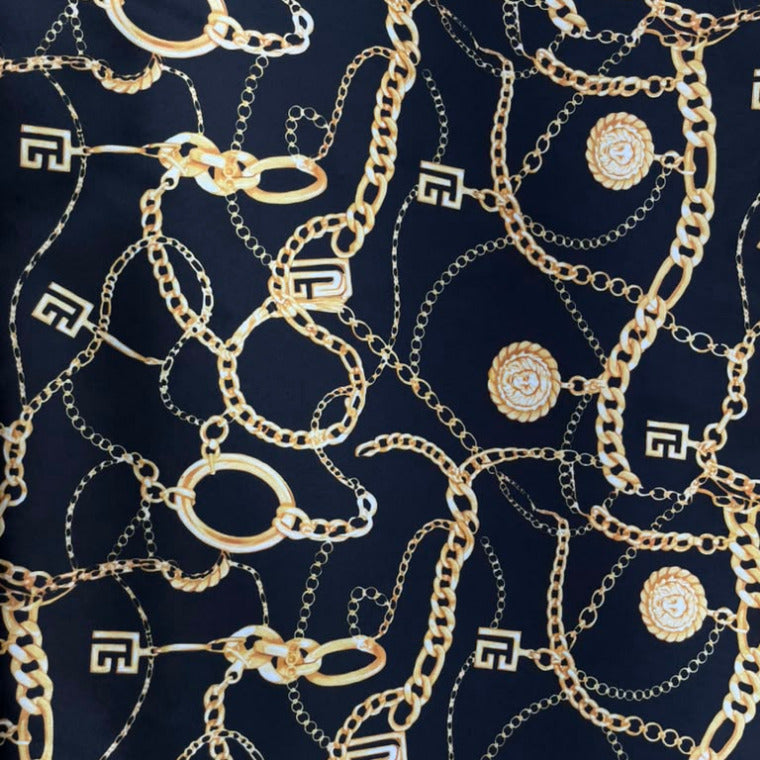 A navy blue fabric featuring an all-over print of gold-tone chains and circular medallion motifs.