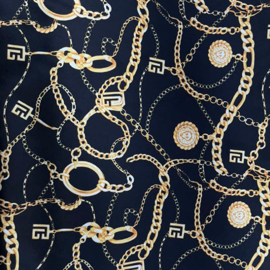 A navy blue fabric featuring an all-over print of gold-tone chains and circular medallion motifs.