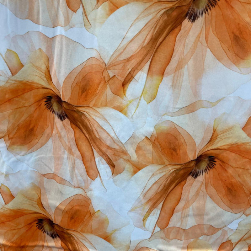 A fabric featuring a large floral pattern in warm orange-brown tones over a white background.