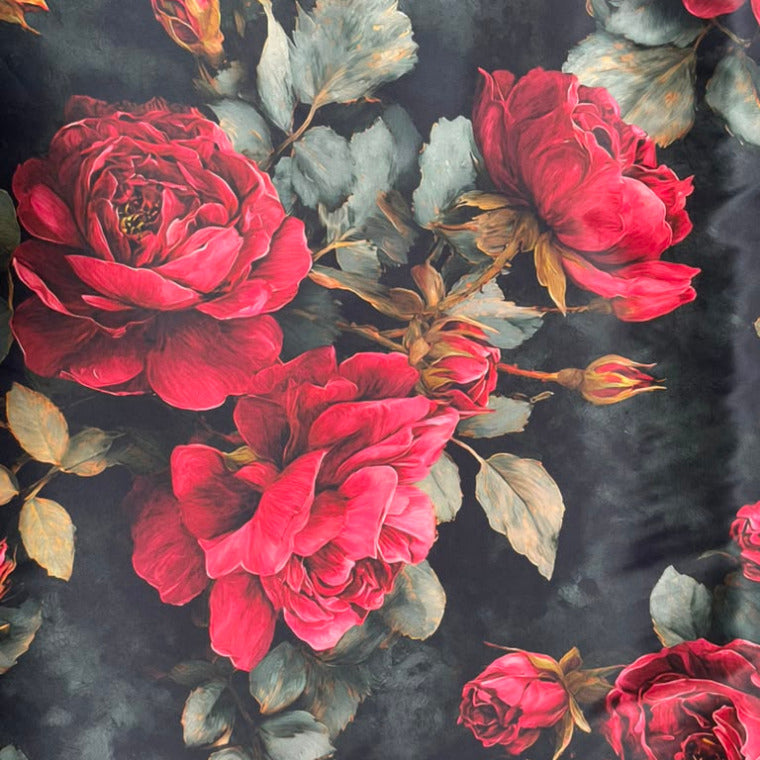 A close-up of a dark floral print featuring large red roses, rosebuds, and muted green-gray leaves on a black background.